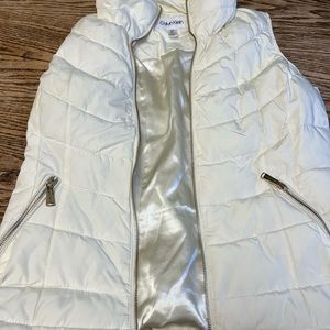 White Calvin Klein puffer vest with gold zippers.
